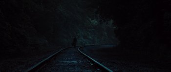 Movie still from “Water for Elephants” (2011), directed by Francis Lawrence – A person walking on a train track in the dark; Extreme Wide shot, High angle