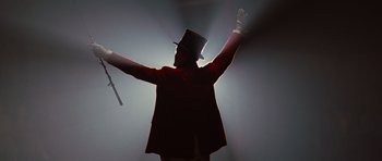 Movie still from “Water for Elephants” (2011), directed by Francis Lawrence – A man wearing a top hat and holding his arms up; Medium shot, Low angle