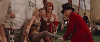 Movie still from “Water for Elephants” (2011), directed by Francis Lawrence – A man in a top hat is helping two women in lingerie; Medium shot, Over the shoulder angle