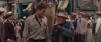 Movie still from “Water for Elephants” (2011), directed by Francis Lawrence – Two men talking to each other in front of an elephant; Medium shot, Over the shoulder angle