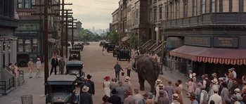 Movie still from “Water for Elephants” (2011), directed by Francis Lawrence – An elephant walking down the street with a crowd of people; Extreme Wide shot, High angle