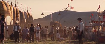 Movie still from “Water for Elephants” (2011), directed by Francis Lawrence – A group of people standing around an elephant in a field; Wide shot, High angle