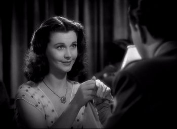 Movie still from “Waterloo Bridge” (1940), directed by Mervyn LeRoy – An old photo of a woman holding a man's hand; Close Up shot, Over the shoulder angle