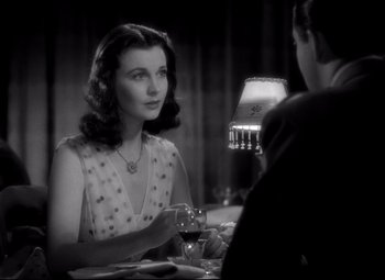 Movie still from “Waterloo Bridge” (1940), directed by Mervyn LeRoy – A woman sitting at a dinner table with a man; Close Up shot, Over the shoulder angle