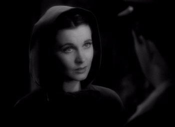 Movie still from “Waterloo Bridge” (1940), directed by Mervyn LeRoy – A black and white photo of a woman wearing a hooded sweatshirt; Close Up shot, High angle