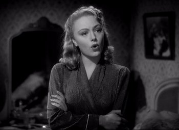 Movie still from “Waterloo Bridge” (1940), directed by Mervyn LeRoy – A black and white photo of a woman with her arms crossed; Medium shot, Low angle