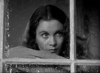 Movie still from “Waterloo Bridge” (1940), directed by Mervyn LeRoy – A black and white photo of a woman looking out of a window; Close Up shot, Low angle