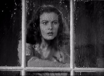 Movie still from “Waterloo Bridge” (1940), directed by Mervyn LeRoy – A black - and - white photo of a woman looking out of a window; Close Up shot, Low angle