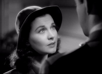Movie still from “Waterloo Bridge” (1940), directed by Mervyn LeRoy – A woman in a hat looking to her left; Close Up shot, Over the shoulder angle