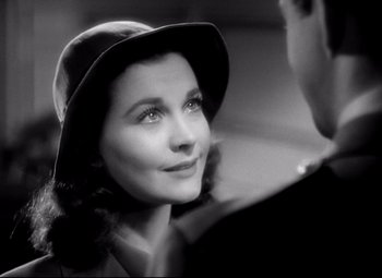 Movie still from “Waterloo Bridge” (1940), directed by Mervyn LeRoy – A woman wearing a hat looking at a man; Close Up shot, Over the shoulder angle