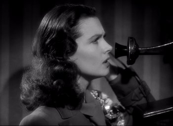 Movie still from “Waterloo Bridge” (1940), directed by Mervyn LeRoy – A woman with long dark hair talking on a phone; Close Up shot, Low angle