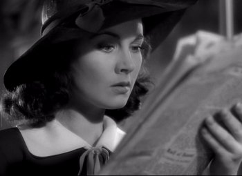Movie still from “Waterloo Bridge” (1940), directed by Mervyn LeRoy – A black and white photo of a woman reading a newspaper; Close Up shot, High angle