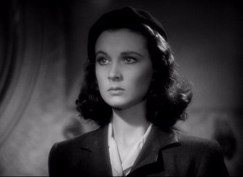 Movie still from “Waterloo Bridge” (1940), directed by Mervyn LeRoy – A woman in a black suit and a black hat; Close Up shot, Low angle