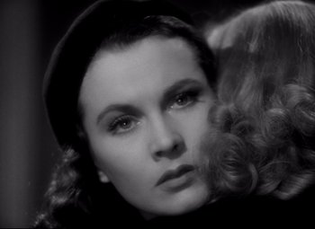 Movie still from “Waterloo Bridge” (1940), directed by Mervyn LeRoy – A black and white photo of a woman with a hat on; Close Up shot, High angle