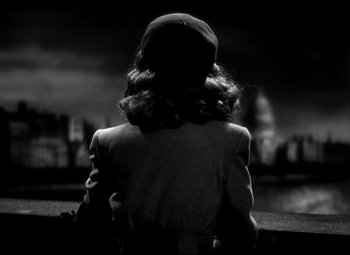 Movie still from “Waterloo Bridge” (1940), directed by Mervyn LeRoy – A black and white photo of a woman looking out over a city; Medium shot, Low angle