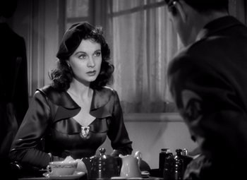 Movie still from “Waterloo Bridge” (1940), directed by Mervyn LeRoy – A woman sitting in front of a man in a room; Close Up shot, Over the shoulder angle