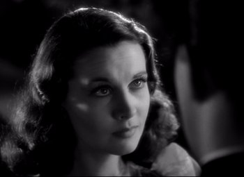Movie still from “Waterloo Bridge” (1940), directed by Mervyn LeRoy – A black - and - white photo of a woman looking at the camera; Close Up shot, Over the shoulder angle