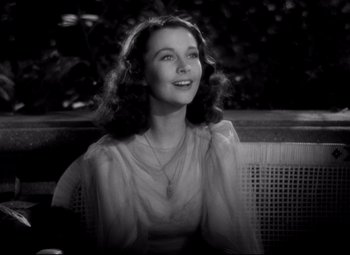 Movie still from “Waterloo Bridge” (1940), directed by Mervyn LeRoy – An old black and white photo of a woman smiling; Close Up shot, High angle