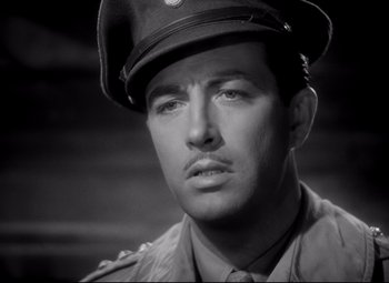 Movie still from “Waterloo Bridge” (1940), directed by Mervyn LeRoy – A man in a military uniform wearing a hat; Close Up shot, High angle