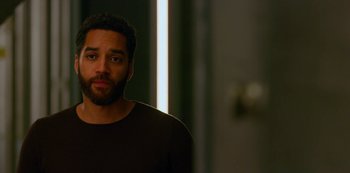 Movie still from “Another Life” (2019), created by Aaron Martin – A person wearing a black t - shirt; Close Up shot, Over the shoulder angle