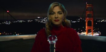 Movie still from “Another Life” (2019), created by Aaron Martin – A woman in a red dress is standing in front of a crystal ball; Close Up shot, Low angle