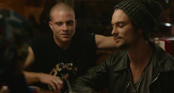Movie still from “We Are Your Friends” (2015), directed by Max Joseph – Two men are sitting at a table and one of the men is holding a knife; Close Up shot, Over the shoulder angle