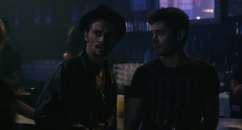 Movie still from “We Are Your Friends” (2015), directed by Max Joseph – Two men standing next to each other in a dark room; Medium shot, Over the shoulder angle