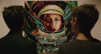 Movie still from “We Are Your Friends” (2015), directed by Max Joseph – Two people looking at a painting of a woman in a space suit; Medium shot, Over the shoulder angle