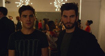 Movie still from “We Are Your Friends” (2015), directed by Max Joseph – A couple of men standing next to each other in a room; Medium shot, Over the shoulder angle