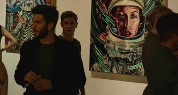 Movie still from “We Are Your Friends” (2015), directed by Max Joseph – Two men standing in front of a painting of a woman; Medium shot, Over the shoulder angle