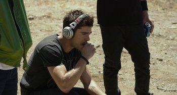 Movie still from “We Are Your Friends” (2015), directed by Max Joseph – A young man with headphones is sitting on the ground; Medium shot, High angle