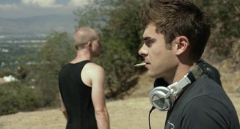 Movie still from “We Are Your Friends” (2015), directed by Max Joseph – A man with headphones and a cigarette in his mouth; Close Up shot, Over the shoulder angle