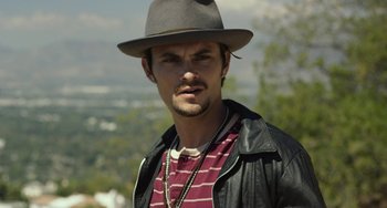 Movie still from “We Are Your Friends” (2015), directed by Max Joseph – A man wearing a hat and a leather jacket; Close Up shot, Over the shoulder angle