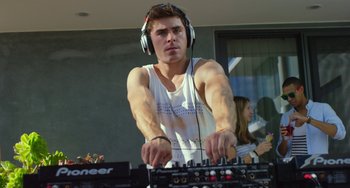 Movie still from “We Are Your Friends” (2015), directed by Max Joseph – A young man wearing headphones while using a dj controller; Medium shot, Low angle