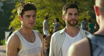 Movie still from “We Are Your Friends” (2015), directed by Max Joseph – Two men standing next to each other in a park; Close Up shot, Over the shoulder angle