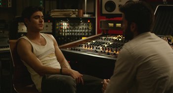 Movie still from “We Are Your Friends” (2015), directed by Max Joseph – Two men sitting in front of each other in front of a sound board; Medium shot, Over the shoulder angle