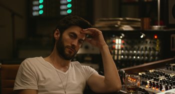 Movie still from “We Are Your Friends” (2015), directed by Max Joseph – A man sitting at a table in front of a glass of wine; Close Up shot, Over the shoulder angle
