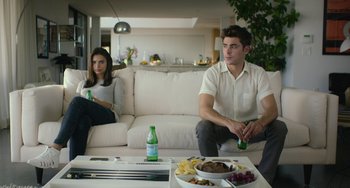 Movie still from “We Are Your Friends” (2015), directed by Max Joseph – A man and a woman sitting on a white couch in a living room; Medium shot, Over the shoulder angle