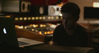 Movie still from “We Are Your Friends” (2015), directed by Max Joseph – A man sitting in front of a laptop computer; Medium shot, High angle