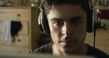 Movie still from “We Are Your Friends” (2015), directed by Max Joseph – A person wearing headphones looking at a computer; Close Up shot, Over the shoulder angle