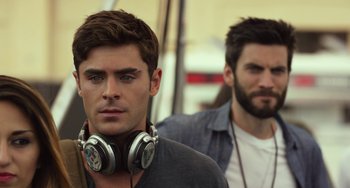 Movie still from “We Are Your Friends” (2015), directed by Max Joseph – A man with a beard and headphones is next to another man; Close Up shot, Over the shoulder angle