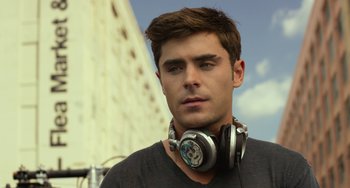 Movie still from “We Are Your Friends” (2015), directed by Max Joseph – A man with headphones is standing in front of a building; Close Up shot, Low angle