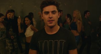 Movie still from “We Are Your Friends” (2015), directed by Max Joseph – A man in a t - shirt standing in front of a group of people; Medium shot, Over the shoulder angle