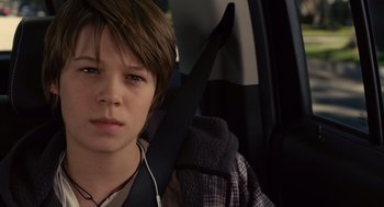 Movie still from “We Bought a Zoo” (2011), directed by Cameron Crowe – A boy with headphones sitting in the back of a car; Close Up shot, Over the shoulder angle