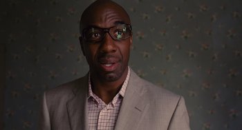 Movie still from “We Bought a Zoo” (2011), directed by Cameron Crowe – A man in a suit and glasses looking at the camera; Close Up shot, Low angle