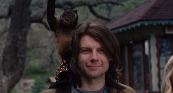 Movie still from “We Bought a Zoo” (2011), directed by Cameron Crowe – A man with long brown hair is holding a monkey; Close Up shot, Low angle