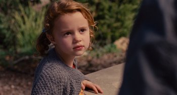 Movie still from “We Bought a Zoo” (2011), directed by Cameron Crowe – A little girl sitting on the ground looking at the camera; Close Up shot, Over the shoulder angle