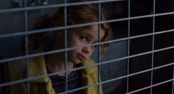 Movie still from “We Bought a Zoo” (2011), directed by Cameron Crowe – A little girl sitting behind a metal fence looking sad; Close Up shot, Over the shoulder angle