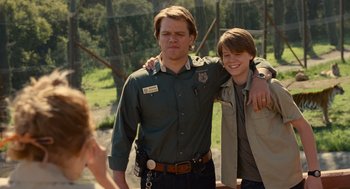 Movie still from “We Bought a Zoo” (2011), directed by Cameron Crowe – A man and a boy posing for a picture together; Medium shot, Over the shoulder angle