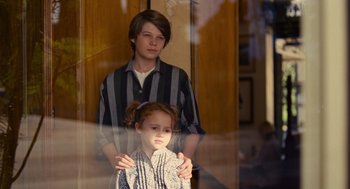 Movie still from “We Bought a Zoo” (2011), directed by Cameron Crowe – A boy and a little girl standing in front of a window; Medium shot, Over the shoulder angle